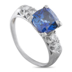 Platinum ring with blue cushion sapphire and diamond accents, split prongs