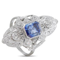 Platinum ring with blue sapphire center, diamond accents, and ornate filigree band