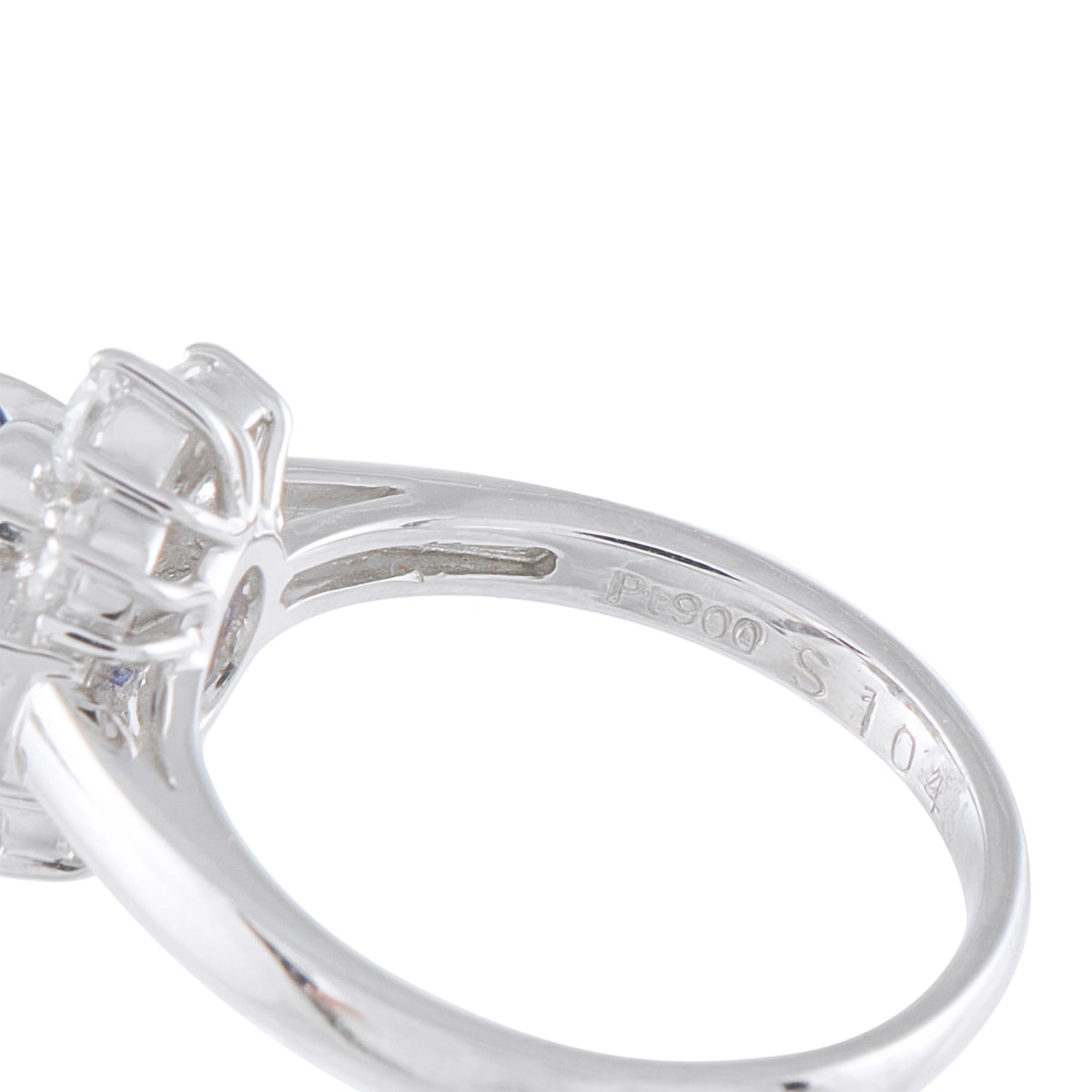 Close-up of platinum ring band with engraved marks and prong setting