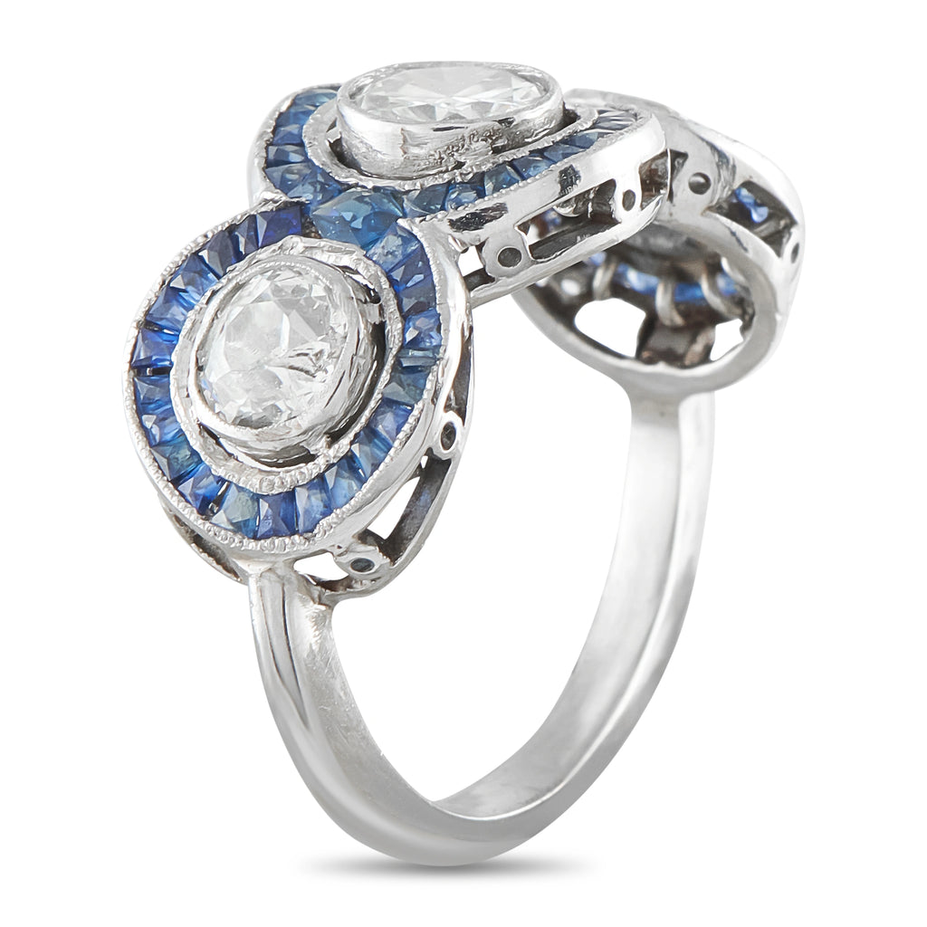 Platinum ring with two oval diamonds in blue sapphire halos, prong-set