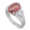 Platinum diamond and spinel ring with an oval pink center stone and clustered side diamonds
