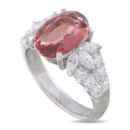 Platinum diamond and spinel ring with an oval pink center stone and clustered side diamonds