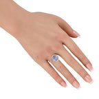 Platinum halo ring on hand featuring a round blue star sapphire center and diamonds
