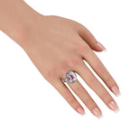 Platinum oval pink gemstone ring on hand, with diamond halo and geometric side settings
