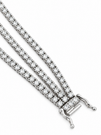 Close-up of triple-row diamond bracelet with white gold fold-over clasp ends.