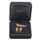 Tiffany & Co. bird brooch displayed in open black gift box with embossed logo