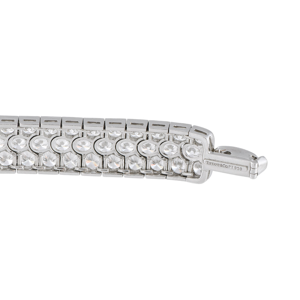 Engraved platinum diamond tennis bracelet with round stone row and clasp detail