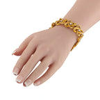 Yellow gold chain bracelet worn on hand, geometric links with diamond accents