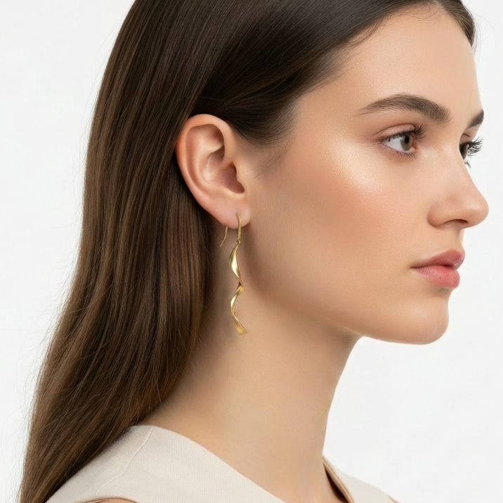 Woman wearing gold hoop earrings on a plain background