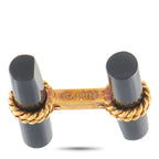 Cufflinks close-up: dark onyx ends with engraved gold bar and gold chain detail