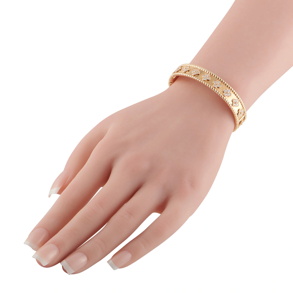 Rose gold diamond bracelet worn on wrist with clover motifs and small stones