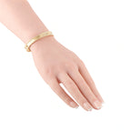 Yellow gold beaded bangle worn on the wrist