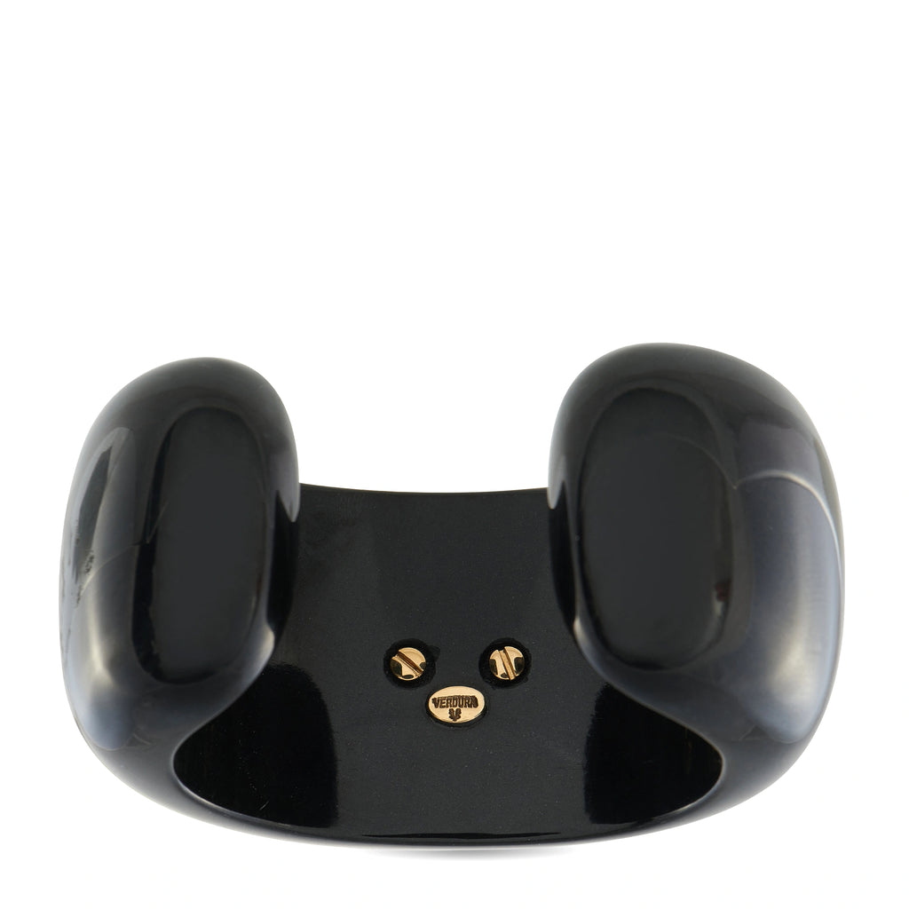 Black cuff bracelet with gold logo studs on side, curved glossy finish