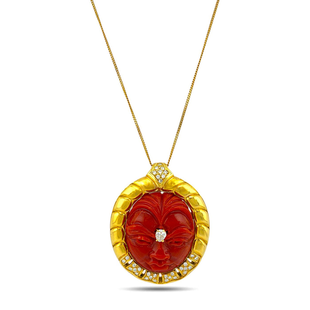 Gold necklace with carved coral face pendant and diamond accents