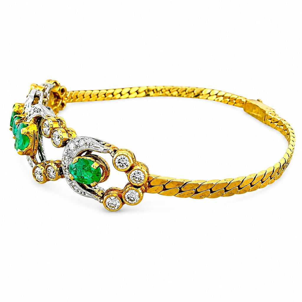 Gold cuff-style bracelet with emerald oval accents, diamond halos, and braided yellow band