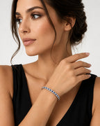 Platinum sapphire tennis bracelet on wrist with blue stones and hinged clasp