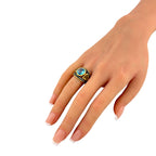 On-hand view of ring featuring oval blue topaz and yellow side stone in gold