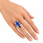 Blue sapphire-style and diamond ring on finger with rose-gold band