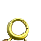 Close-up of gold tone circular link with engraved marking on adjacent link