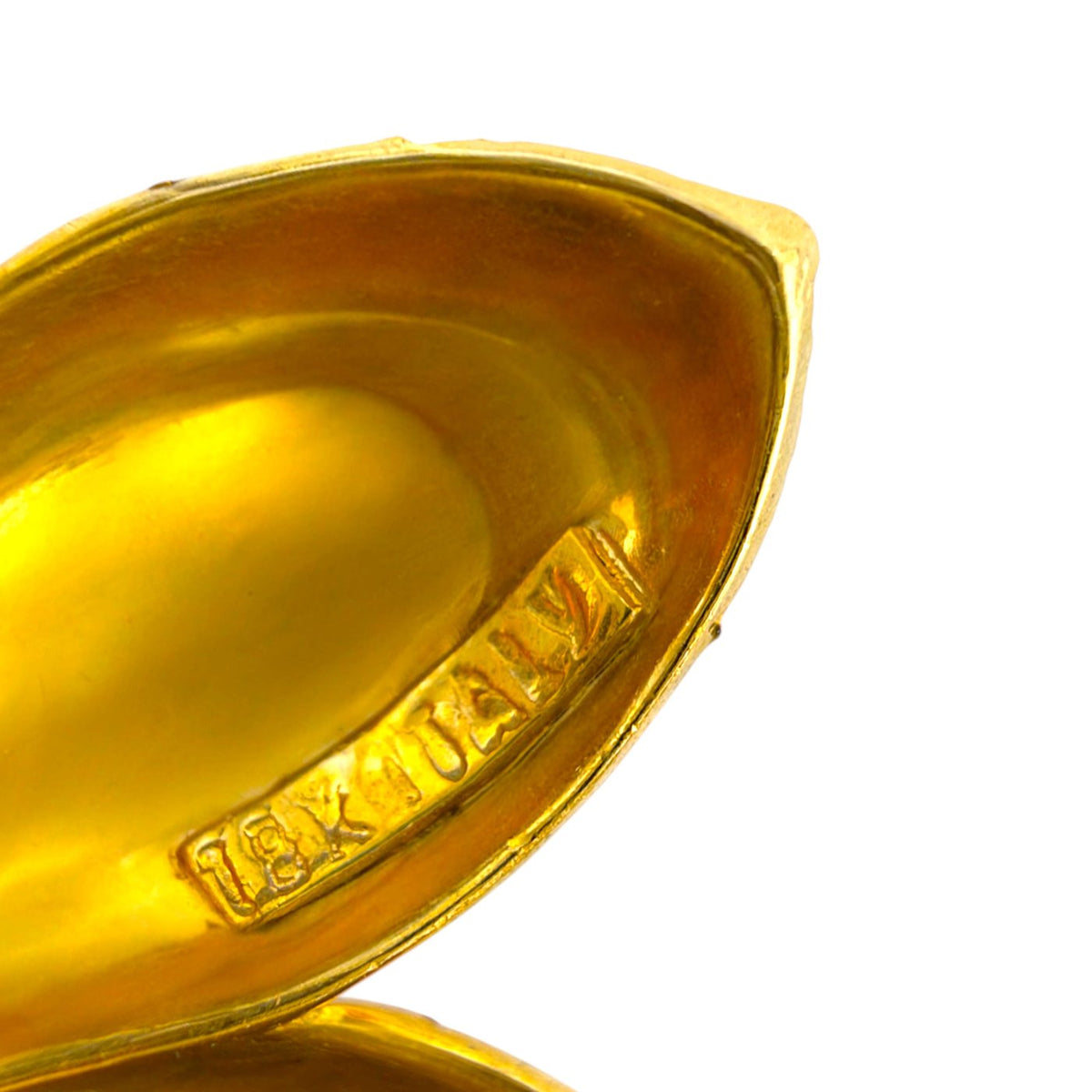 Close-up of the gold earring interior with a stamped hallmark
