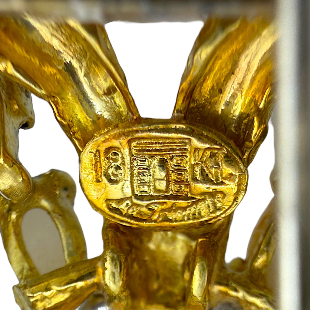 Gold hallmark stamp reading 18K on brooch back, with enamel and metal details