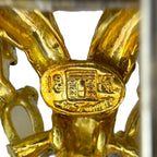Gold hallmark stamp reading 18K on brooch back, with enamel and metal details