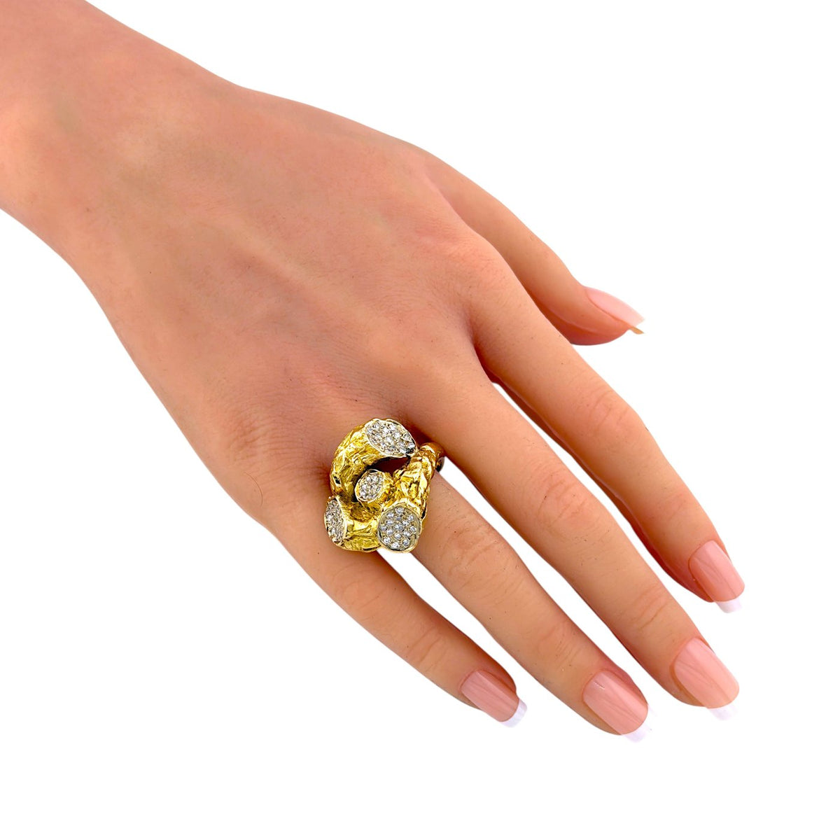 Sculptural yellow gold ring with diamond clusters worn on a hand