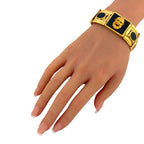 Gold bloodstone face bracelet worn on hand with two black-and-red square panels