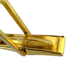 Gold cufflink backing plate with hinged post detail and engraved bar, close-up