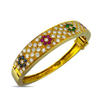 Gold hinged cuff bracelet with diamond pave and clustered sapphire, ruby, emerald, and green stones