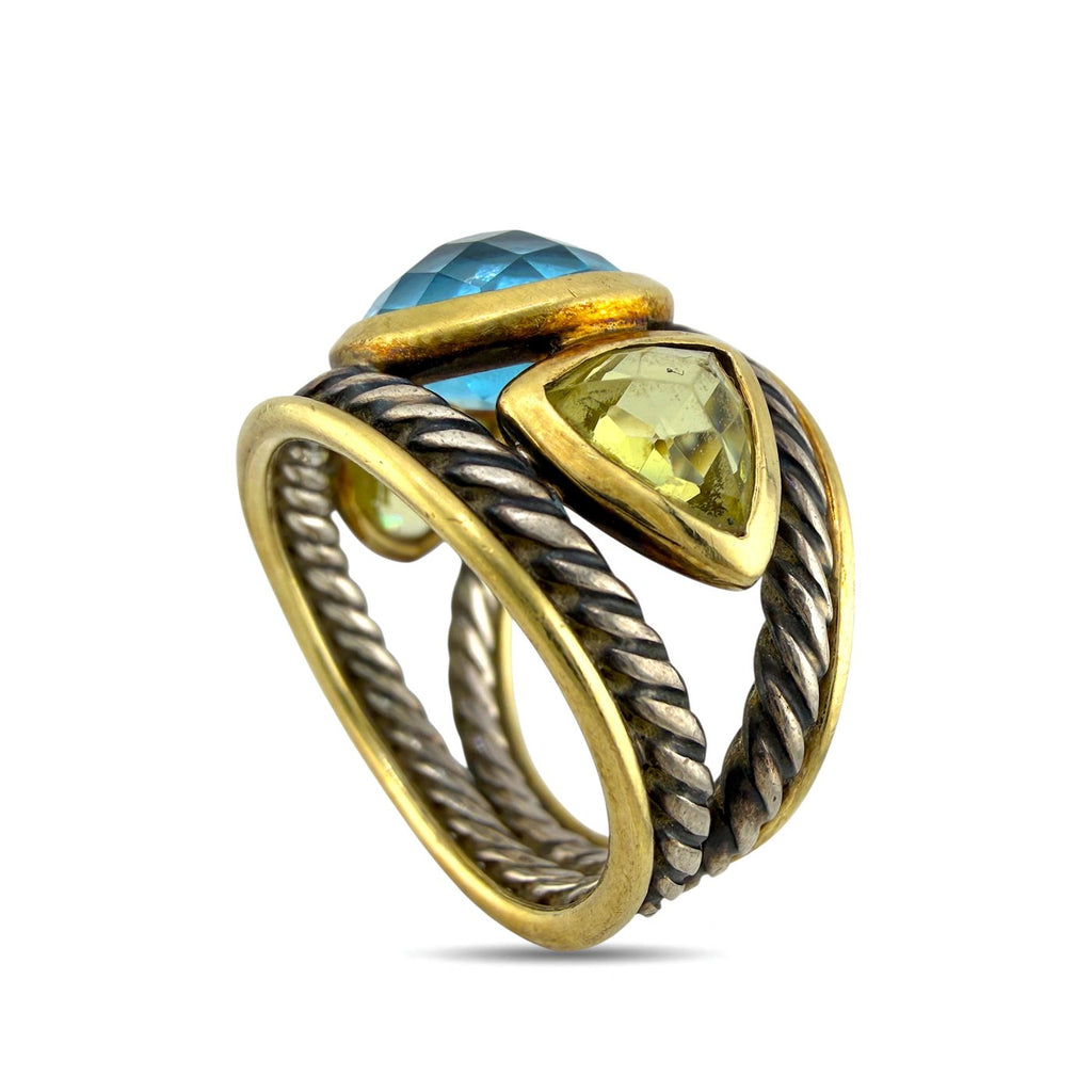 Angled view ring with oval blue topaz top and yellow side stone set in gold
