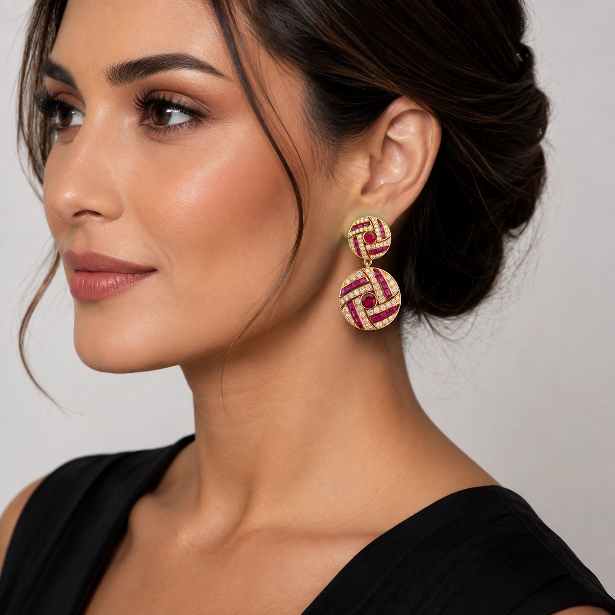 Ruby and diamond drop earrings on ear, gold round tops with purple gemstone inlays