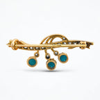 Reverse of the brooch showing its pin clasp and turquoise settings