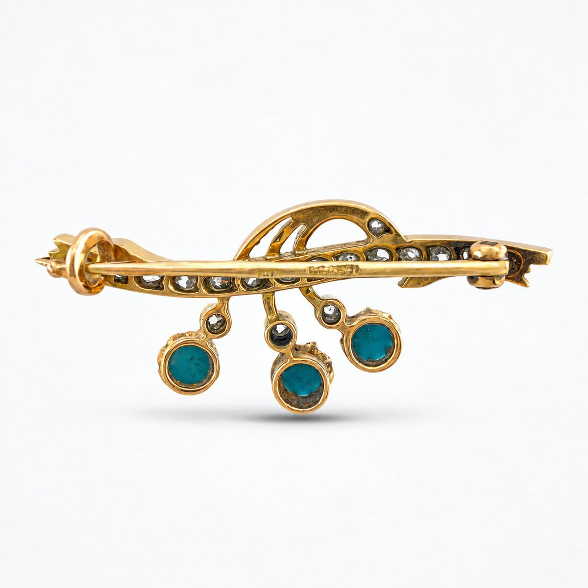 Reverse of the brooch showing its pin clasp and turquoise settings