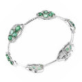 White gold diamond and emerald bangle with oval emerald accents in halo settings