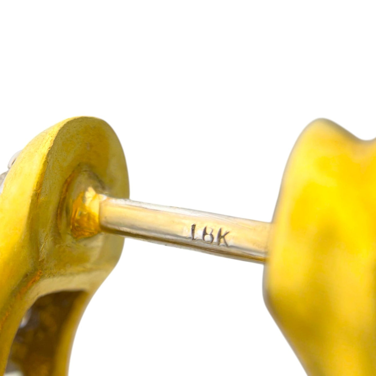 Close-up of a gold earring post stamped 18K