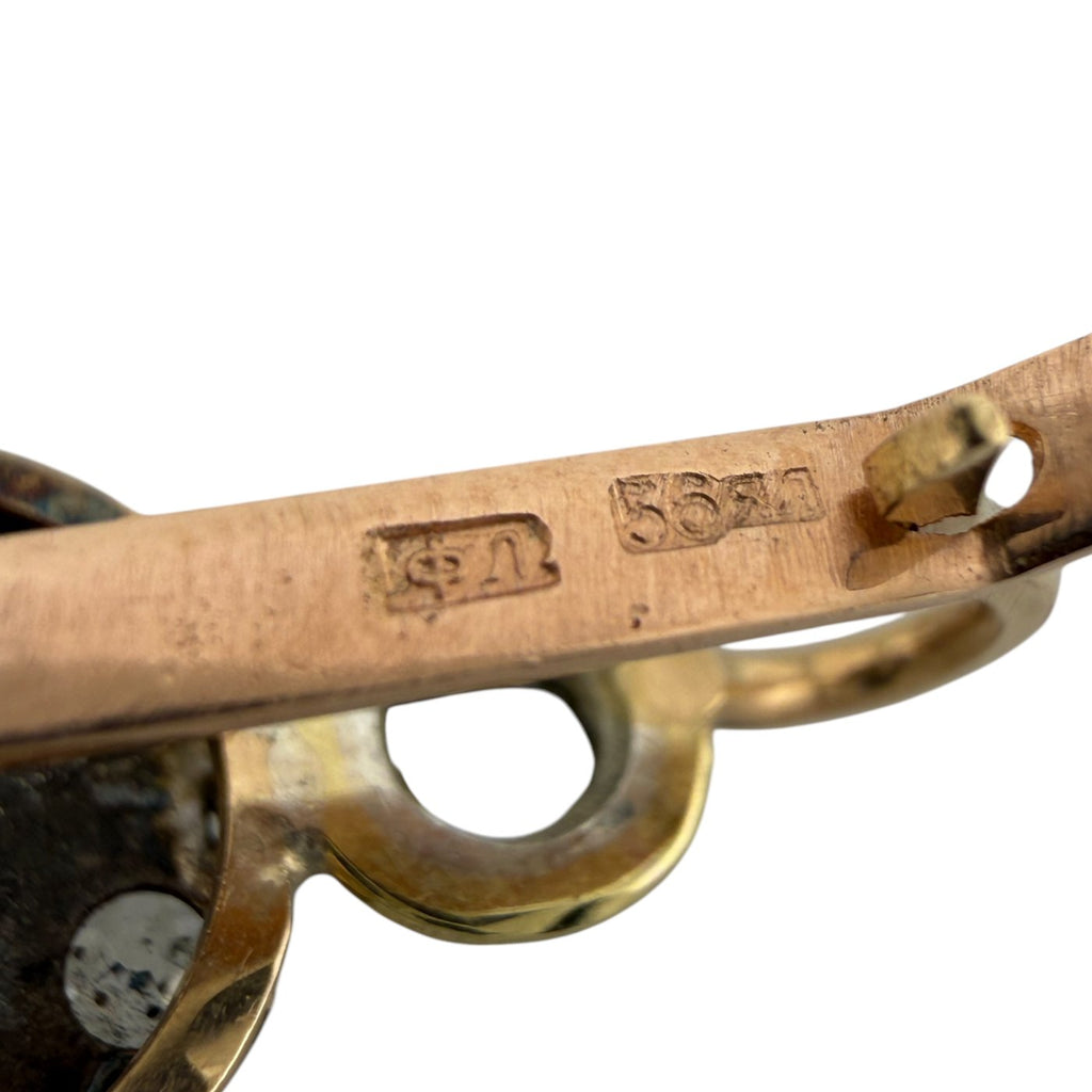Rose gold earring clasp hinge with stamped hallmark on metal bar.