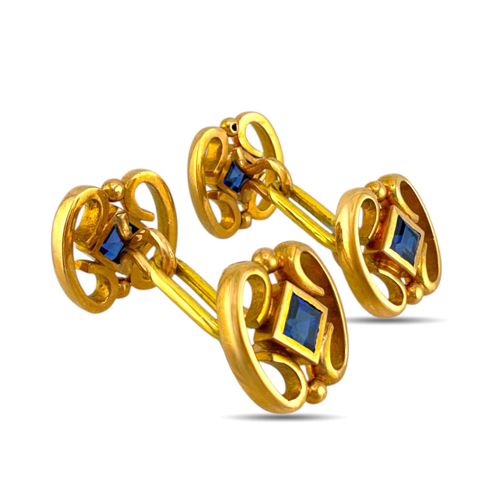 Gold sapphire cufflinks shown from an angled side view, revealing their connecting bars