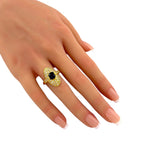 18K yellow gold ring with oval dark center stone and diamond halo