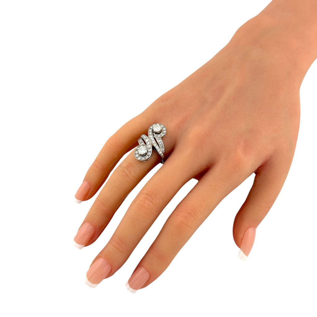 18K white gold diamond ring with swirl design on a hand