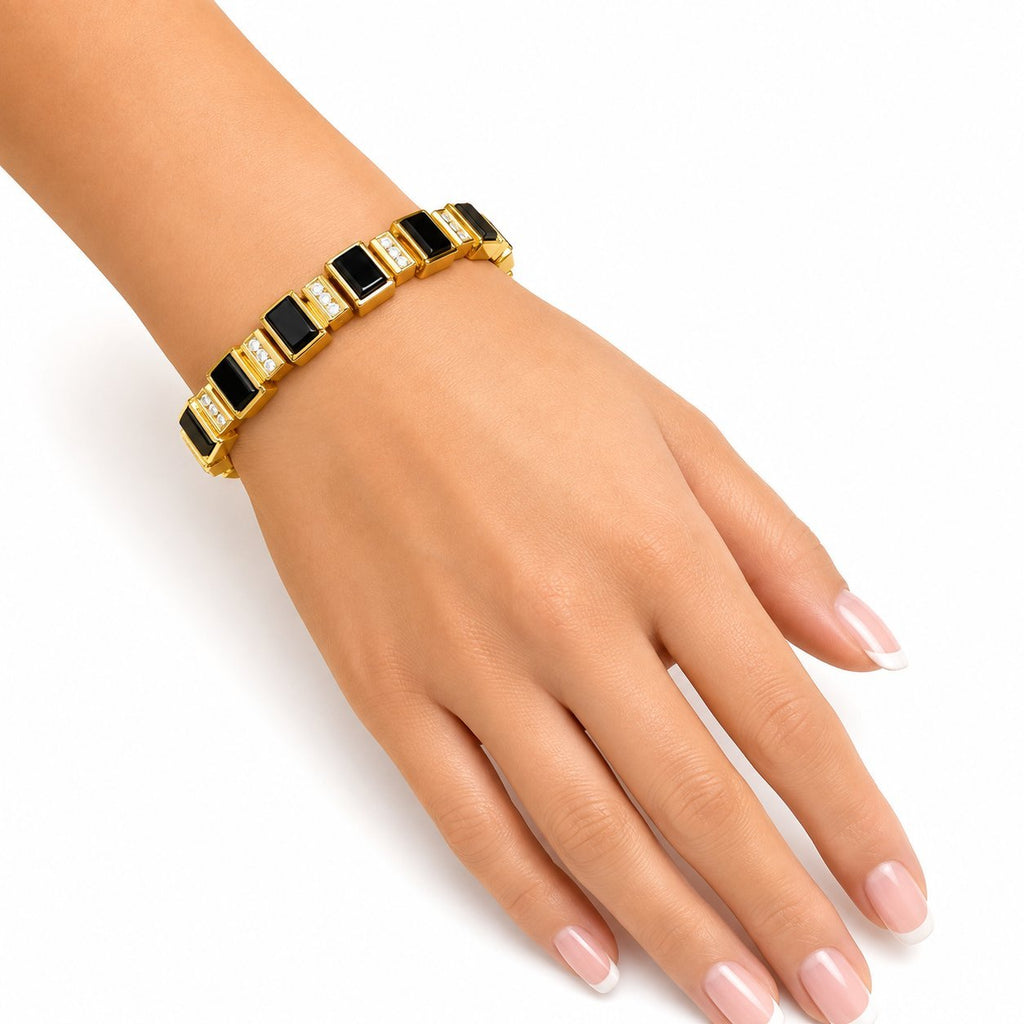 Gold onyx and diamond link bracelet worn on wrist with black square panels