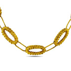 Gold textured oval-link necklace detail with central oval clasp