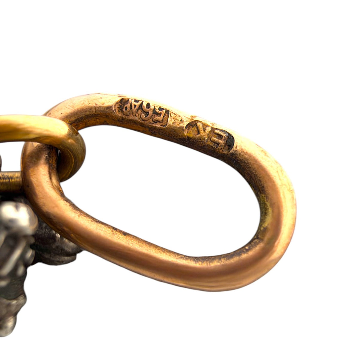 Close-up of the gold pendant bail showing an engraved hallmark