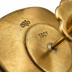 Close-up of gold earring back showing 18CT hallmark and post attachment