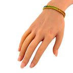 Rainbow gemstone bracelet worn on the wrist, showing green and amber stones