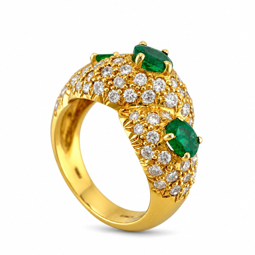 Gold band ring with emerald cabochons and round diamond clusters across the top