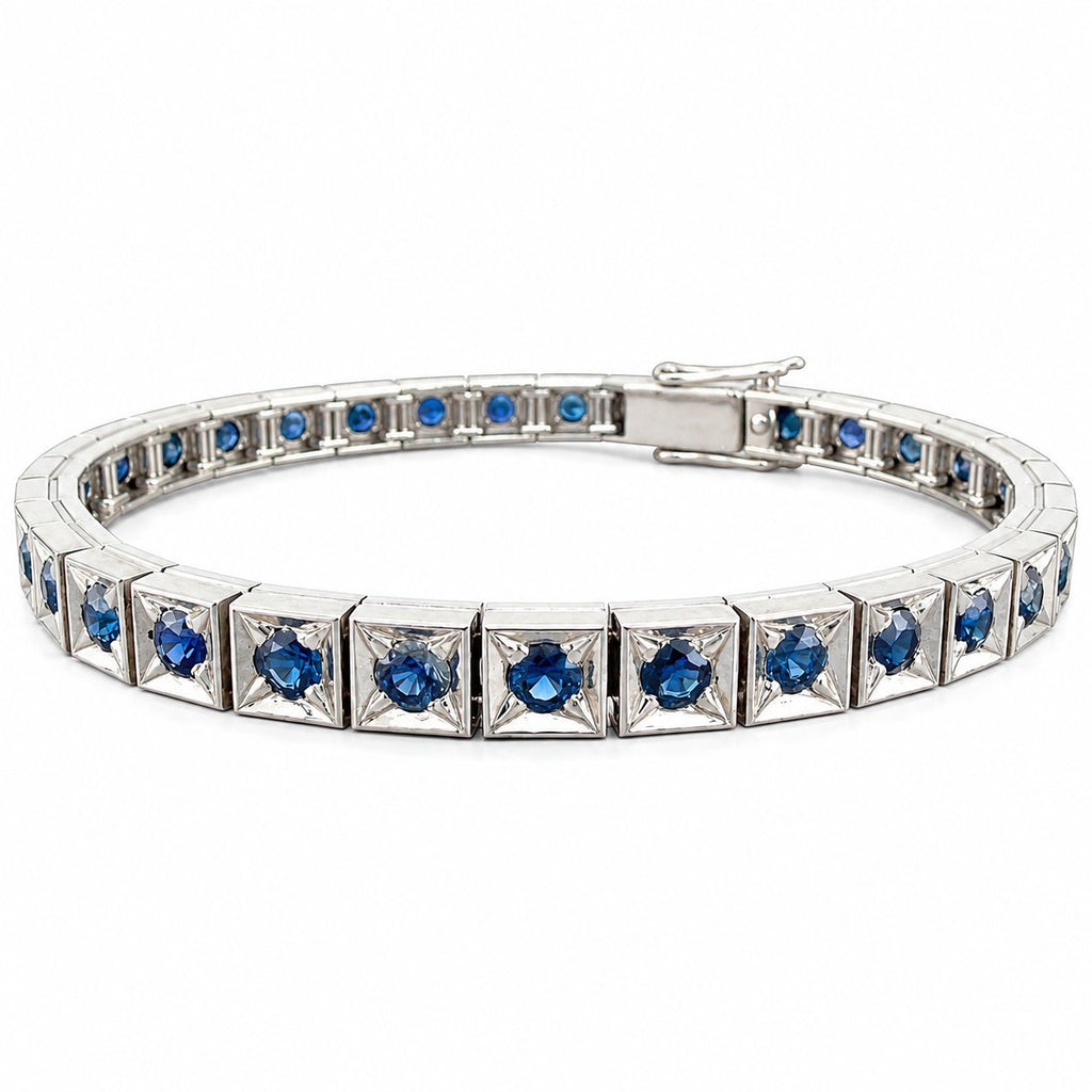Platinum sapphire tennis bracelet with blue stones set across a slim silver link band