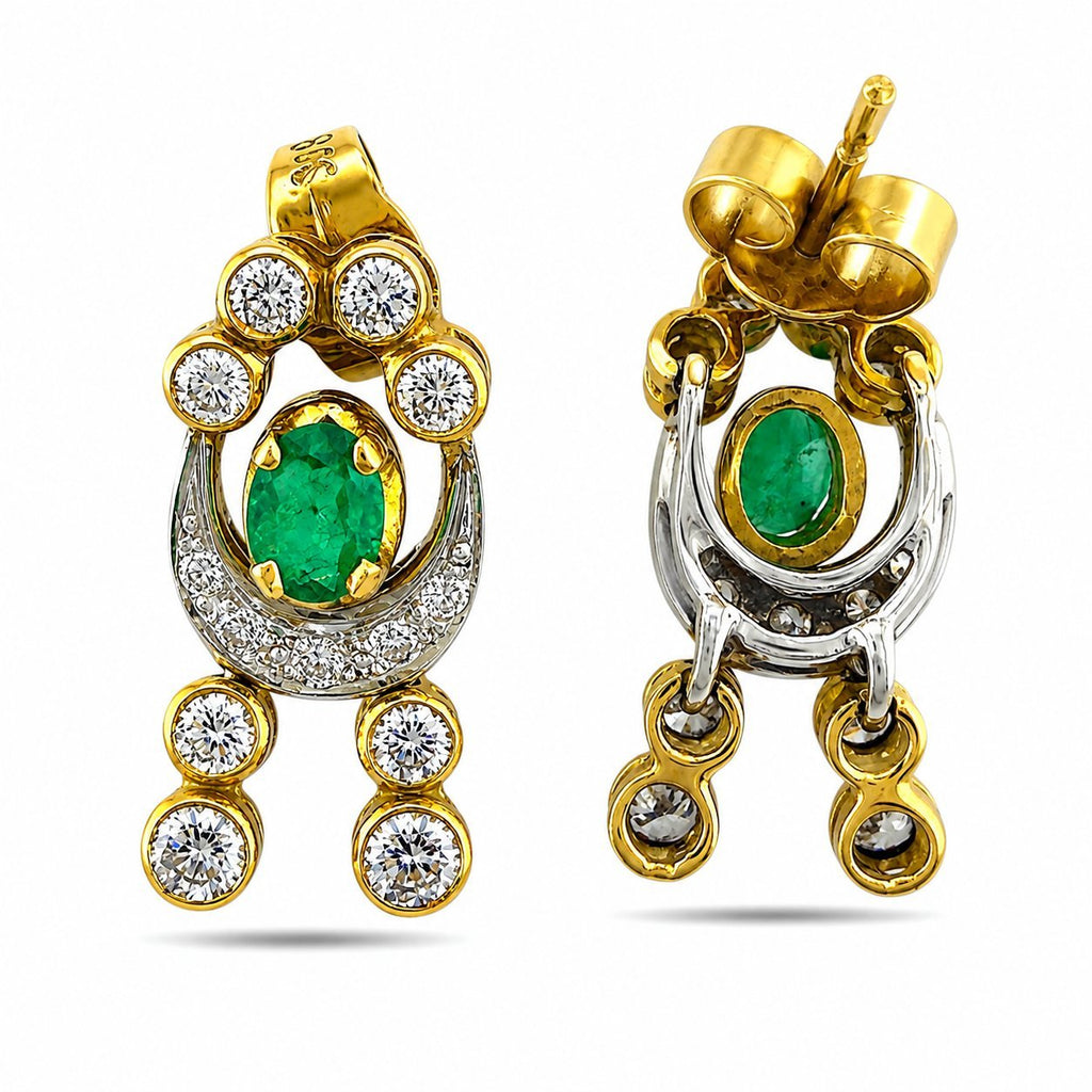 Pair of gold-and-silver earrings with emerald oval centers and diamond round dangling stones