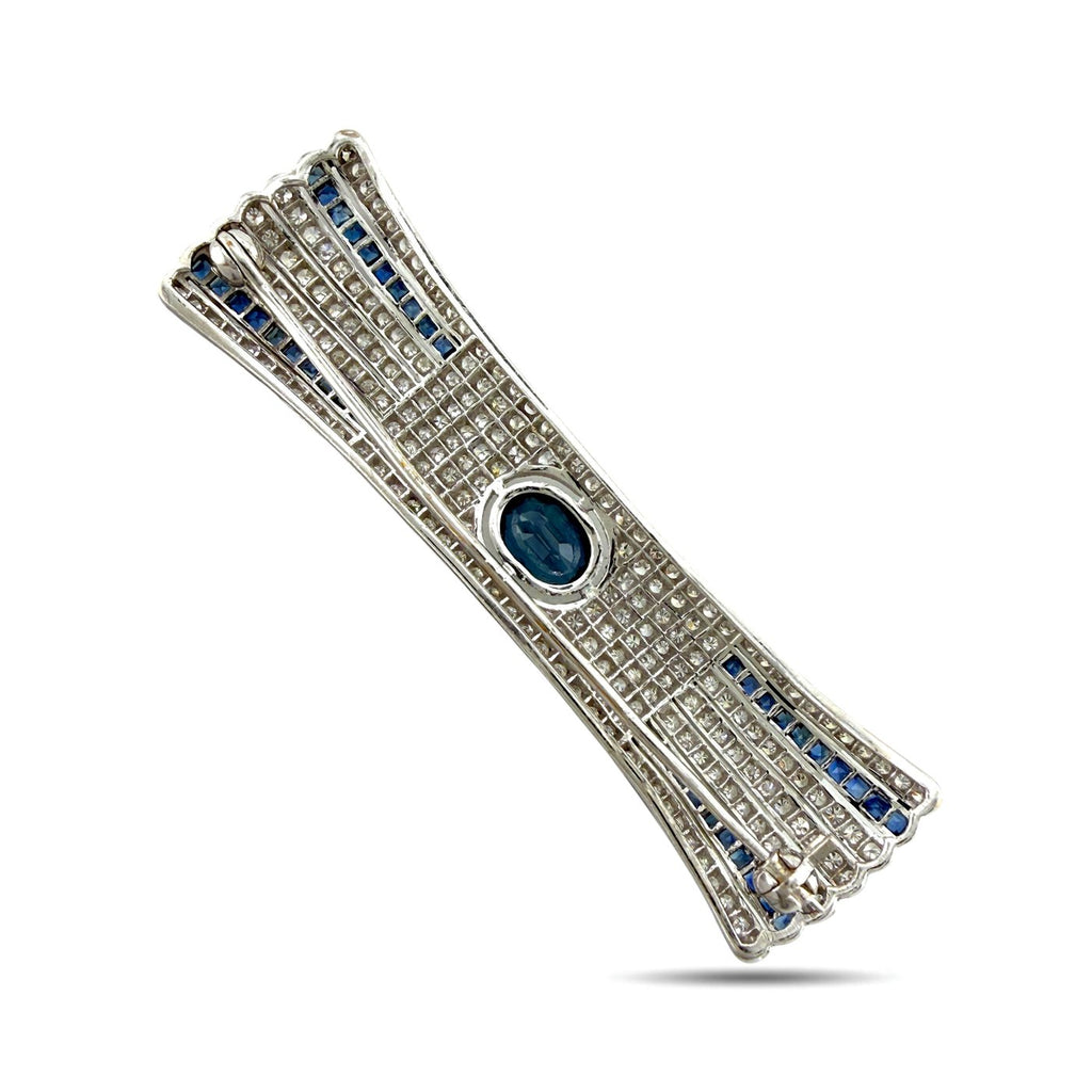 Diamond bar brooch angled view with blue sapphire stripe borders and oval blue center stone