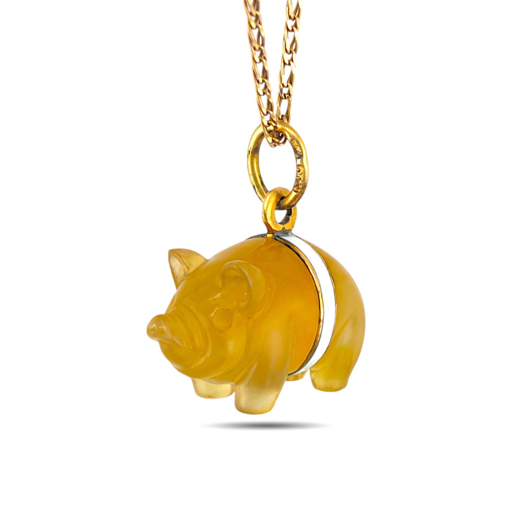 Pig pendant shown from the opposite side, with a white enamel band and gold-tone chain.